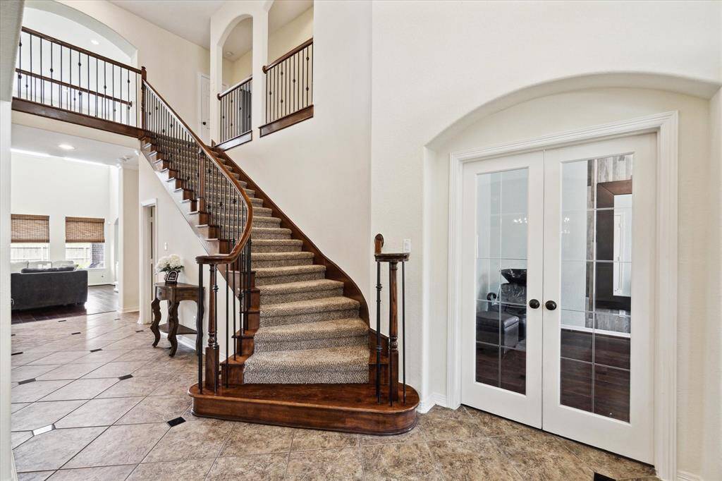 Stunning foyer welcomes you in featuring a curved staircase with wrought iron balusters, soaring high ceilings, and elegant arch details throughout. Study/office is located to the right of entry with formal dining directly across.