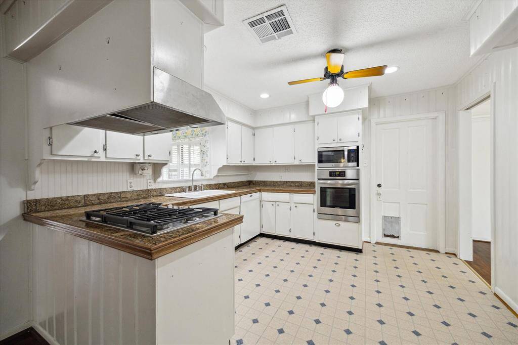 Kitchen is open and door leads to garage.