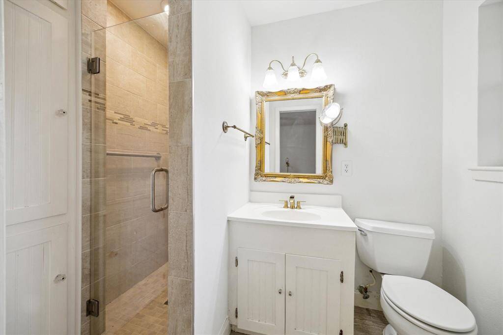 Primary bathroom with a heavy glass shower door.