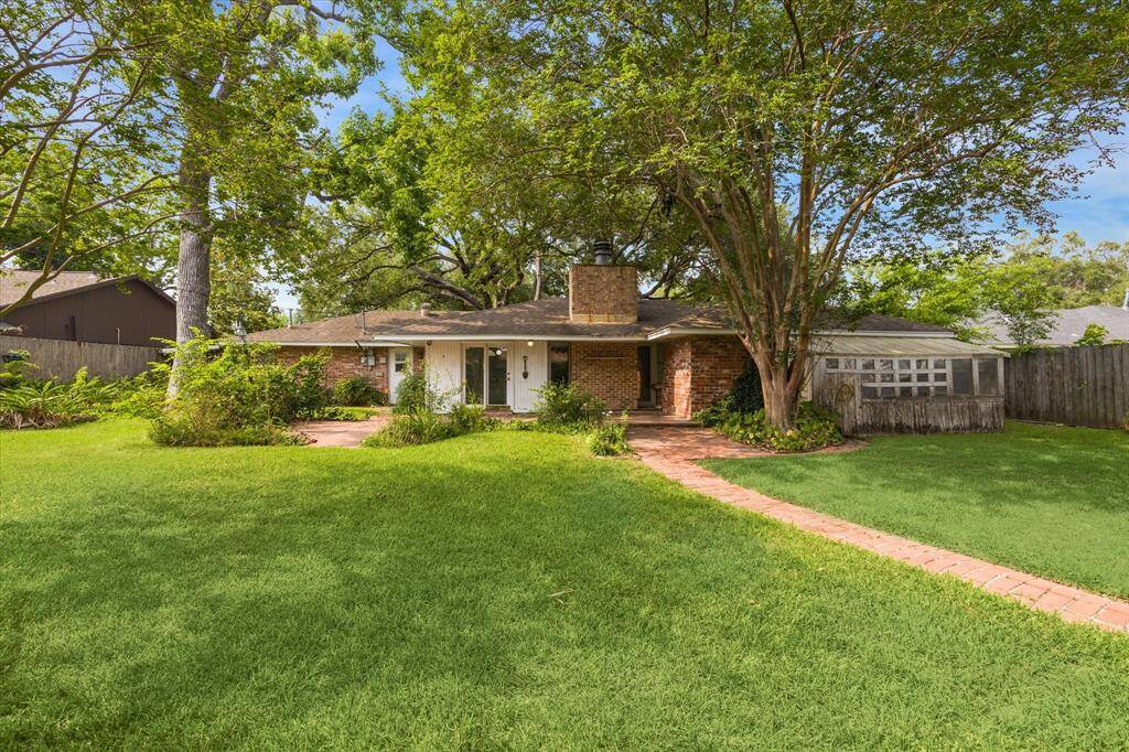 You can appreciate the size of the backyard.  The greenhouse is located on the right and the white glass door leads to the breakfast/dining room.  Wonderful mature trees in the front and the back of the property.