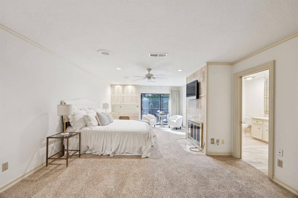 Expansive primary suite with fireplace, private balcony, and sitting area.