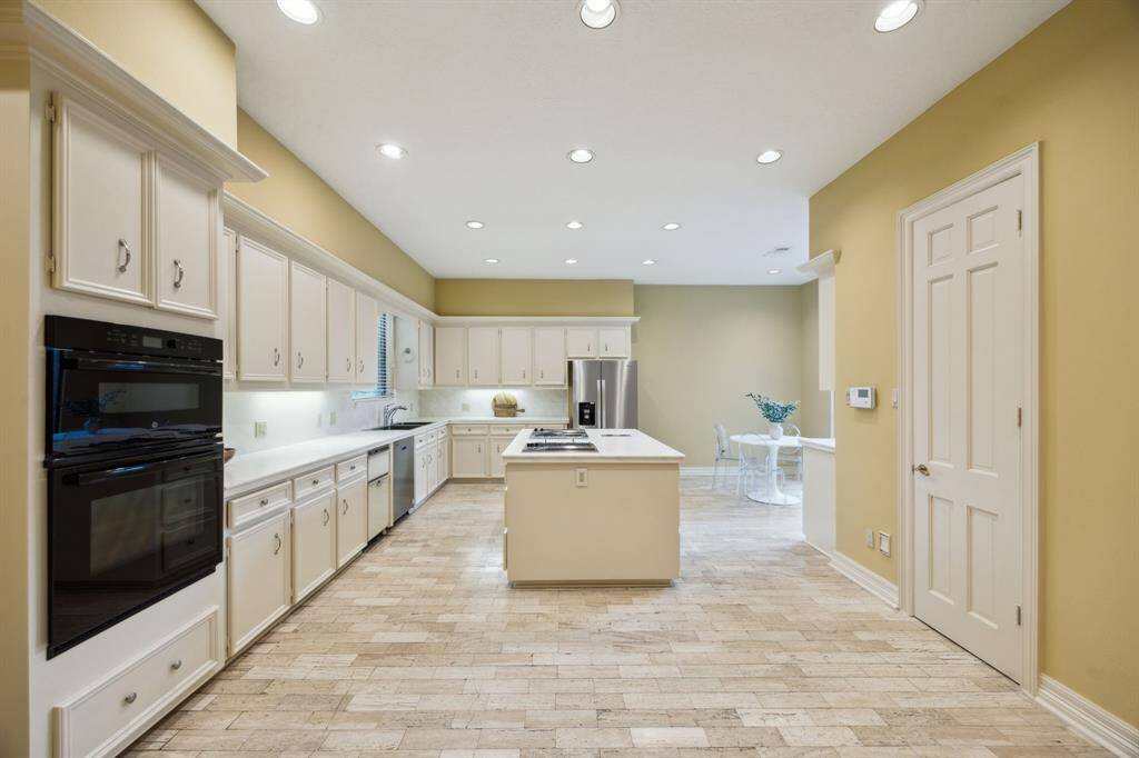 Island kitchen features walk-in pantry, stainless steel dishwasher, recessed lighting, and breakfast room.