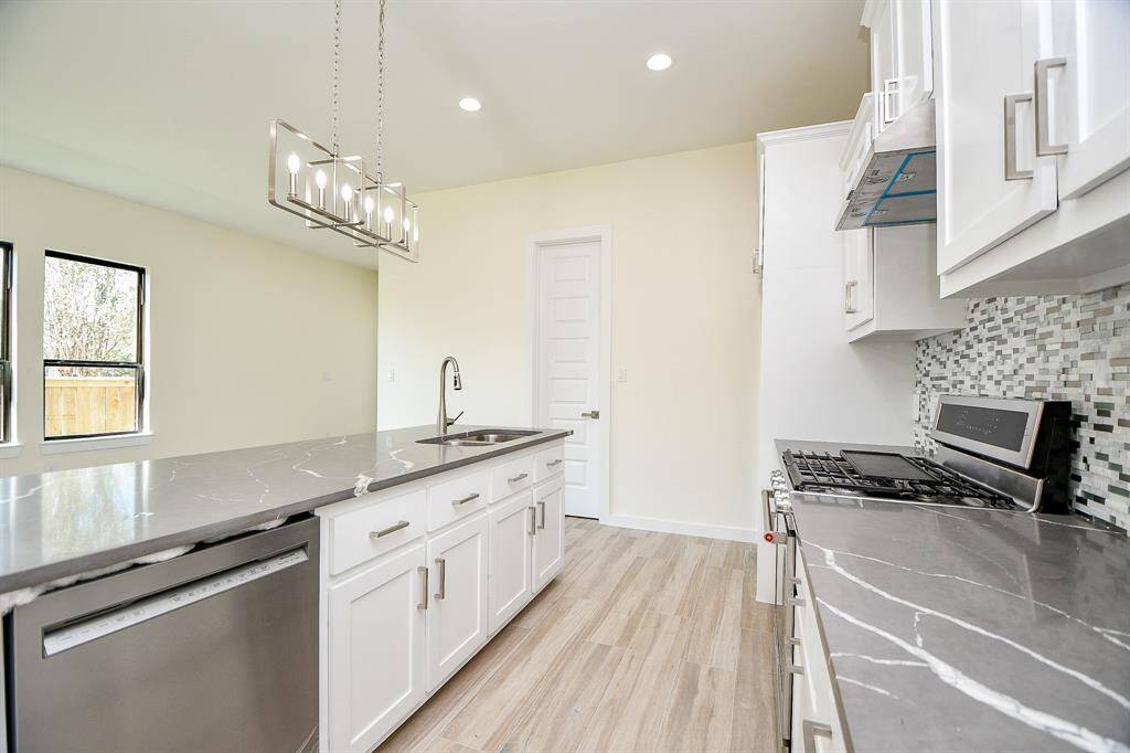 A chef's dream! Well-lit open Kitchen is perfect for entertaining featuring a large quartz island with breakfast bar seating, SS appliances & a large pantry.