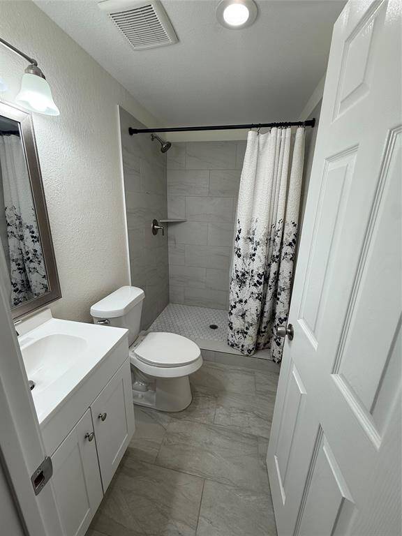 Contemporary and stylish, this bath features a tiled shower with crisp lines and a white vanity that echoes the home’s overall design integrity. A space that feels as fresh as it is functional.