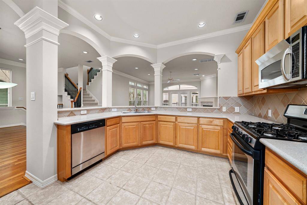 The chef’s kitchen features ceramic tile flooring, generous cabinetry, and granite counters for ample prep space. Stainless steel appliances, recessed lighting, and a breakfast bar complete the functionality and charm.