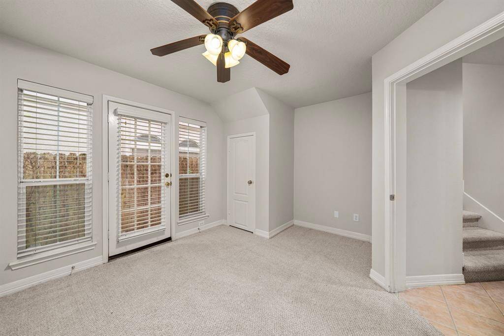 A bright and versatile space on the lower level with French doors leading to the backyard. Natural light pours in through multiple windows, and there's easy access to the adjacent hallway and stairs.