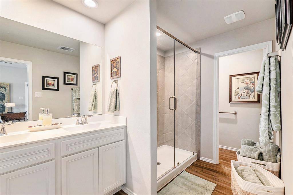 Ensuite bathroom with dual sinks, oversized shower, and a walk-in closet—designed for both comfort and functionality.