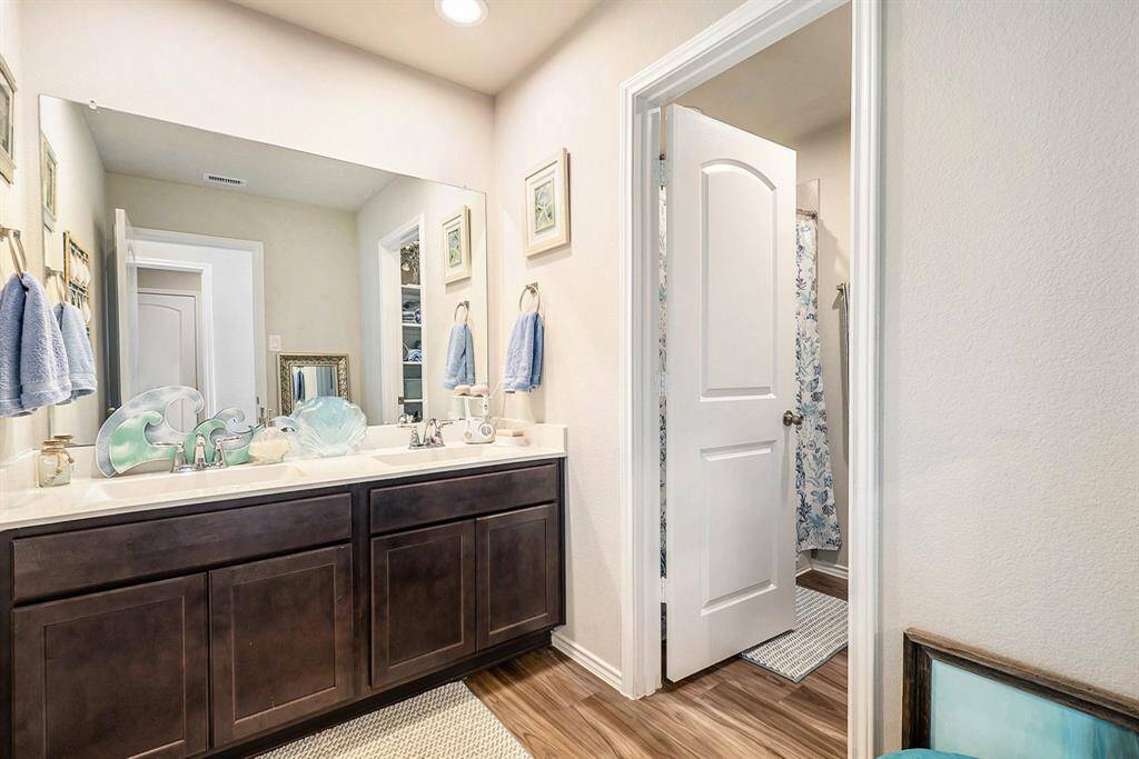Clean and modern full bathroom conveniently located between secondary bedrooms, featuring updated finishes and ample storage.