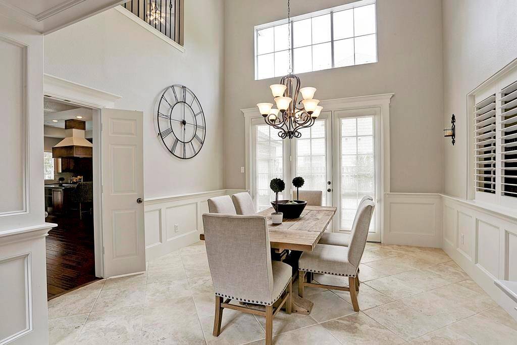 The dining room boasts a wall of french doors and architectural windows that bathes the room in natural light.  It also features a set of french doors for service access to the kitchen.
