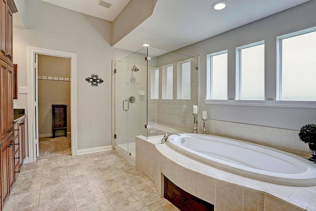 The master features a seamless shower and jetted tub.  Natural light streams through the architectural windows.