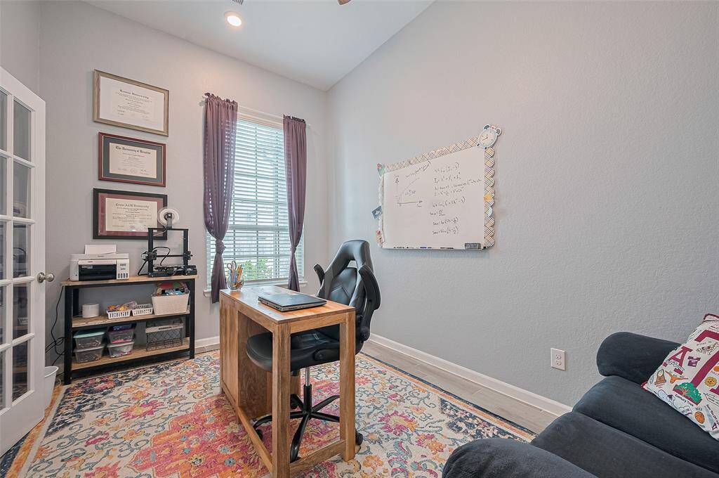 Bright study offers ample natural light through a large window and provides a quiet, focused environment for work or learning. French doors add a touch of elegance while maintaining privacy and openness.