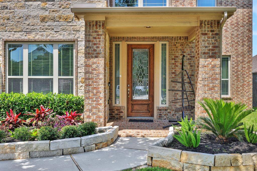 Welcoming front porch leads to a soaring two-story foyer
