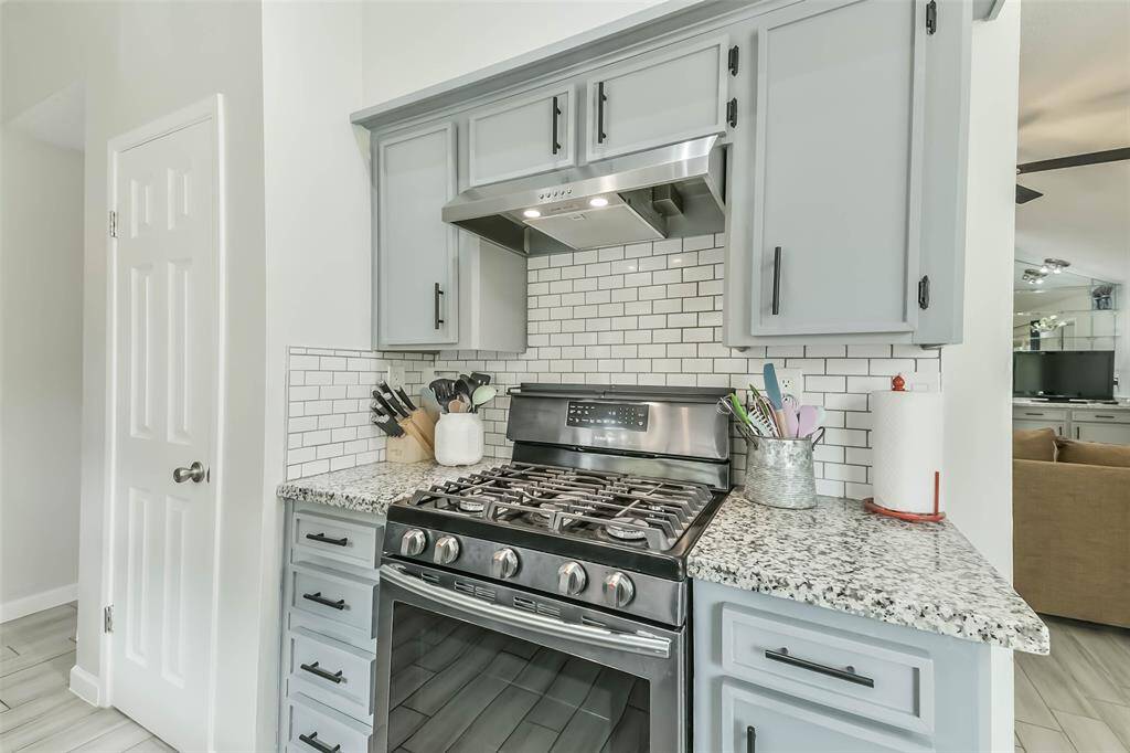 Beautiful granite counters and subway tile backsplash surround this 5 burner updated gas range.