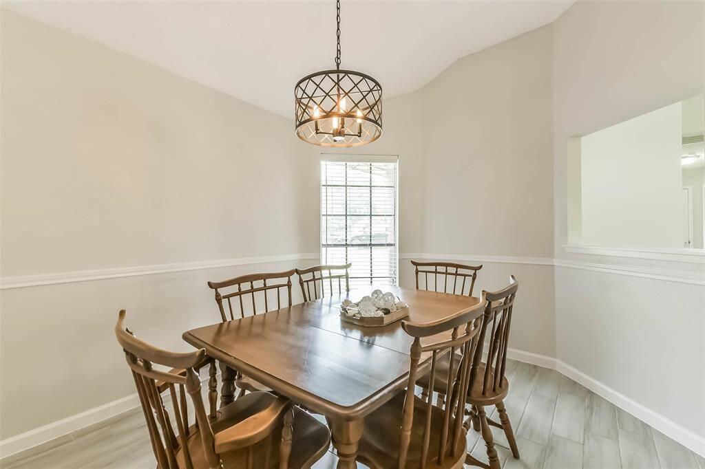 Updated chandelier, wood look tile, and chair railing highlight this formal dining room.