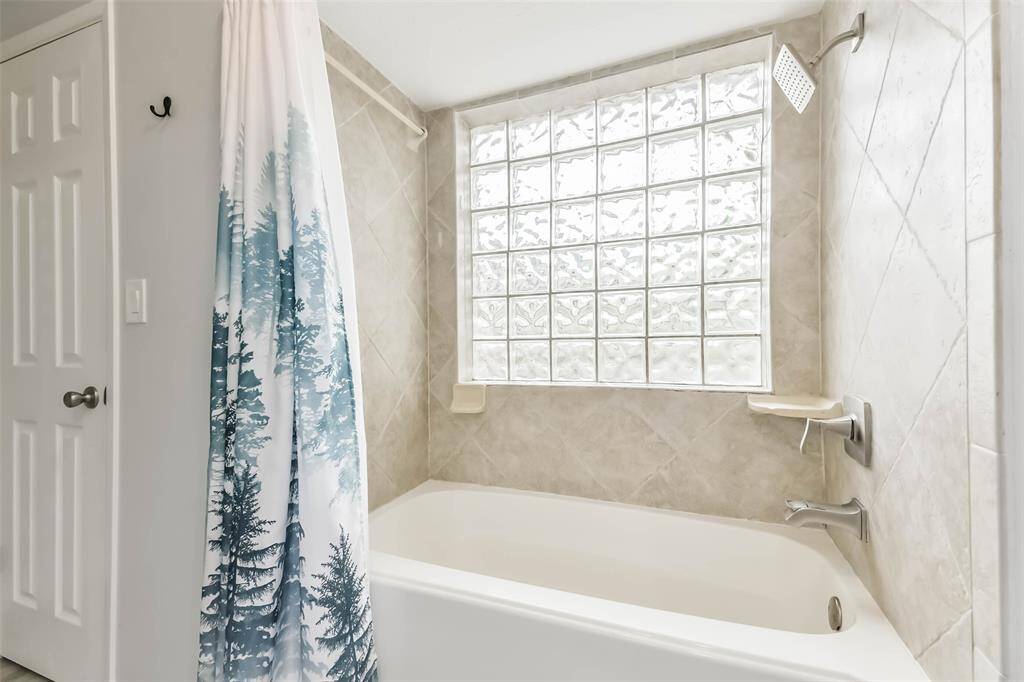 Glass block window provides privacy and ample light in this primary bathroom.
