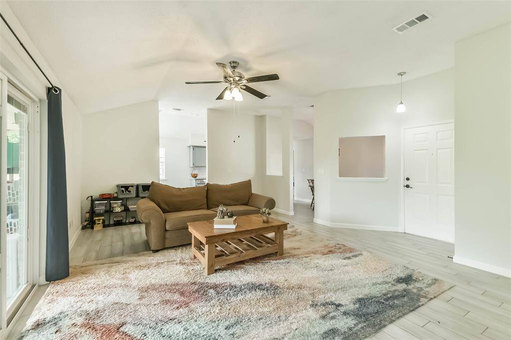 Wood look tile covers the floors in the living room, formal dining, breakfast room, kitchen, and hall. The living room is central to all the areas of the home.