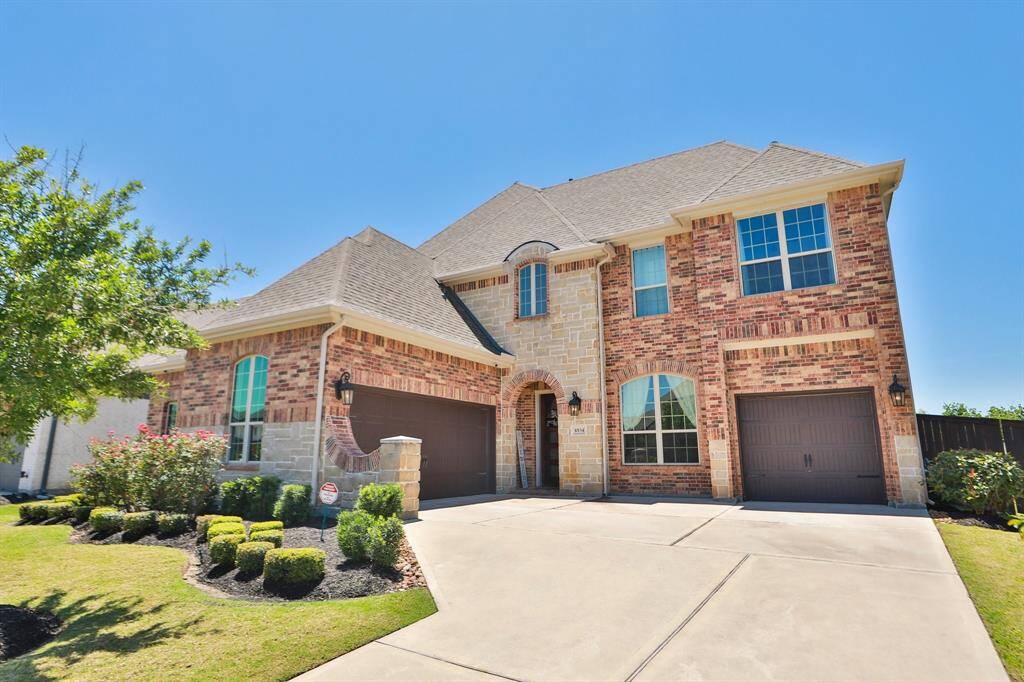 Beautiful landscaping and stone accent the front of the house.