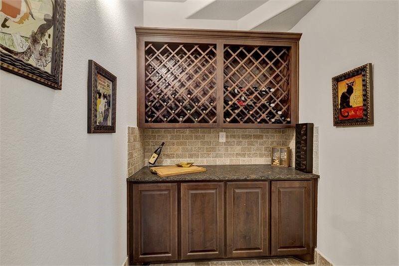 The wine room with custom wood cabinetry, granite countertops and a built-in wine rack is perfect for entertaining!