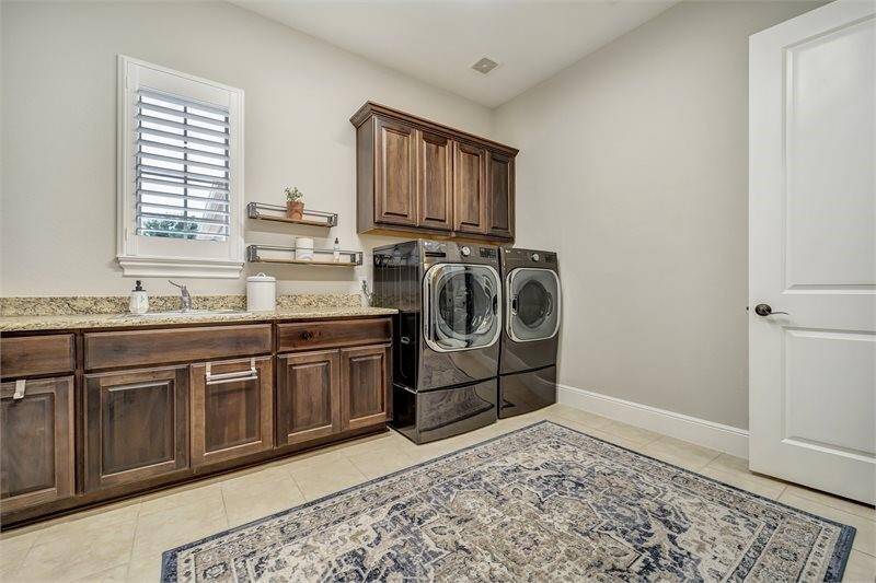Spacious laundry room with ample storage and a large utility sink.