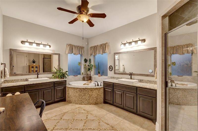 Primary suite features his and her vanity with a spacious soaking tub to enhance your relaxation experience.