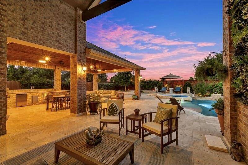 Spacious covered patio, outdoor kitchen featuring large gas grill, refrigerator, sink and stainless drawers and level 3 high-grade granite countertop — perfect for relaxing.