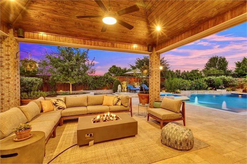 Spacious covered patio with ceiling fans and integrated speaker systems perfect for relaxing or entertaining guests.