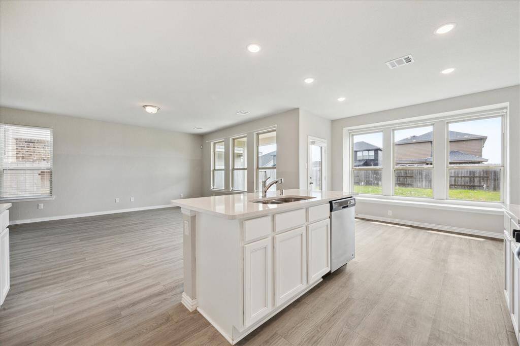 THE OPEN DESIGN INCORPORATES THE DEN, KITCHEN AND DINING AREA TO THE RIGHT.