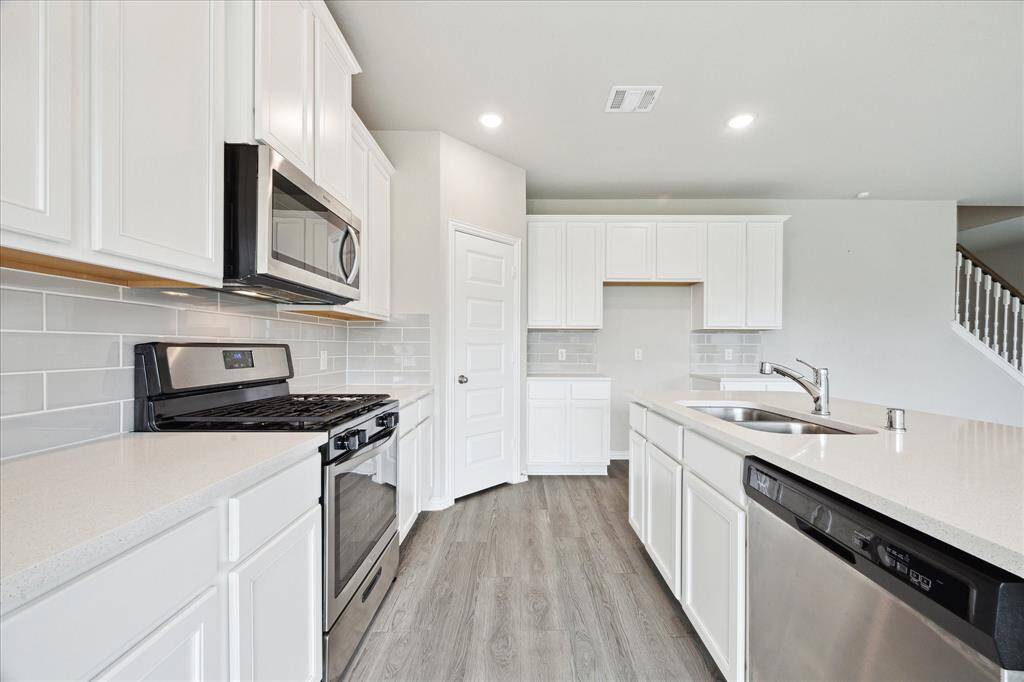 THE KITCHEN FEATURES A STAINLESS-STEEL GAS RANGE AND MICROWAVE.