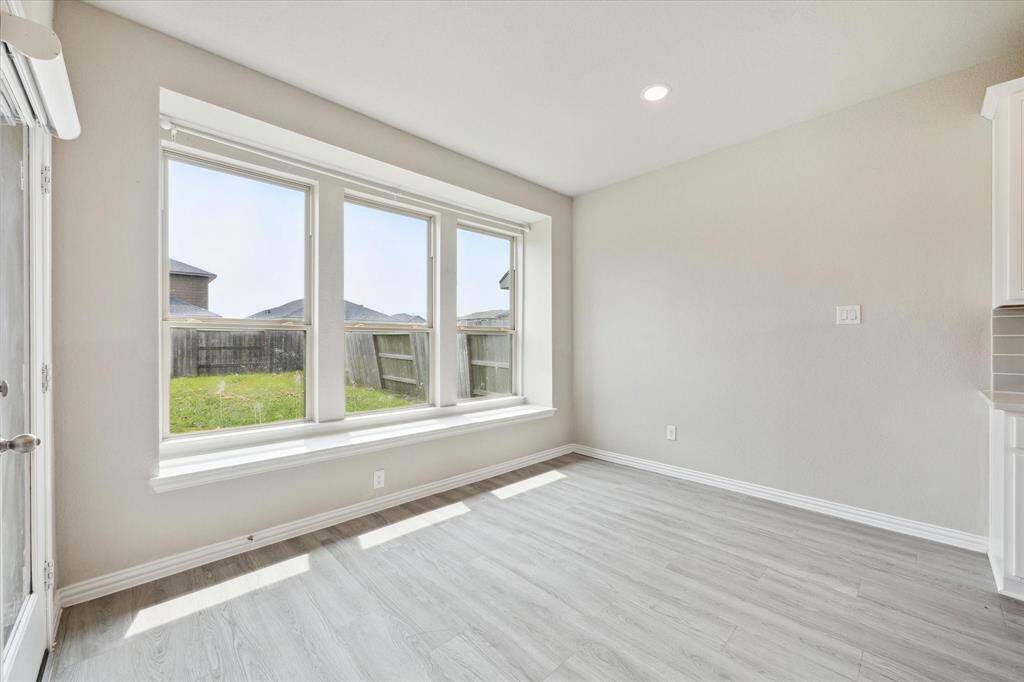 SPACIOUS DINING AREA WITH A WINDOW SEAT OVERLOOKING THE BACKYARD.
