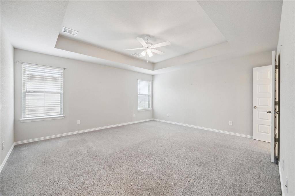 OVERSIZED PRIMARY SUITE WITH A COFFERED CEILING.