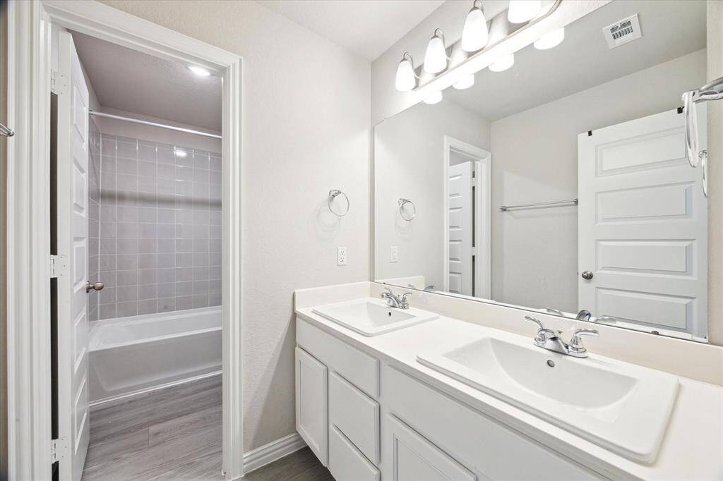 2ND FULL BATH WITH DOUBLE SINKS AND A TUB/SHOWER COMBO WITH TILE SURROUND.