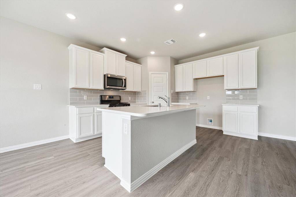 BEAUTIFUL ISLAND KITCHEN WITH QUARTZ COUNTERS.
