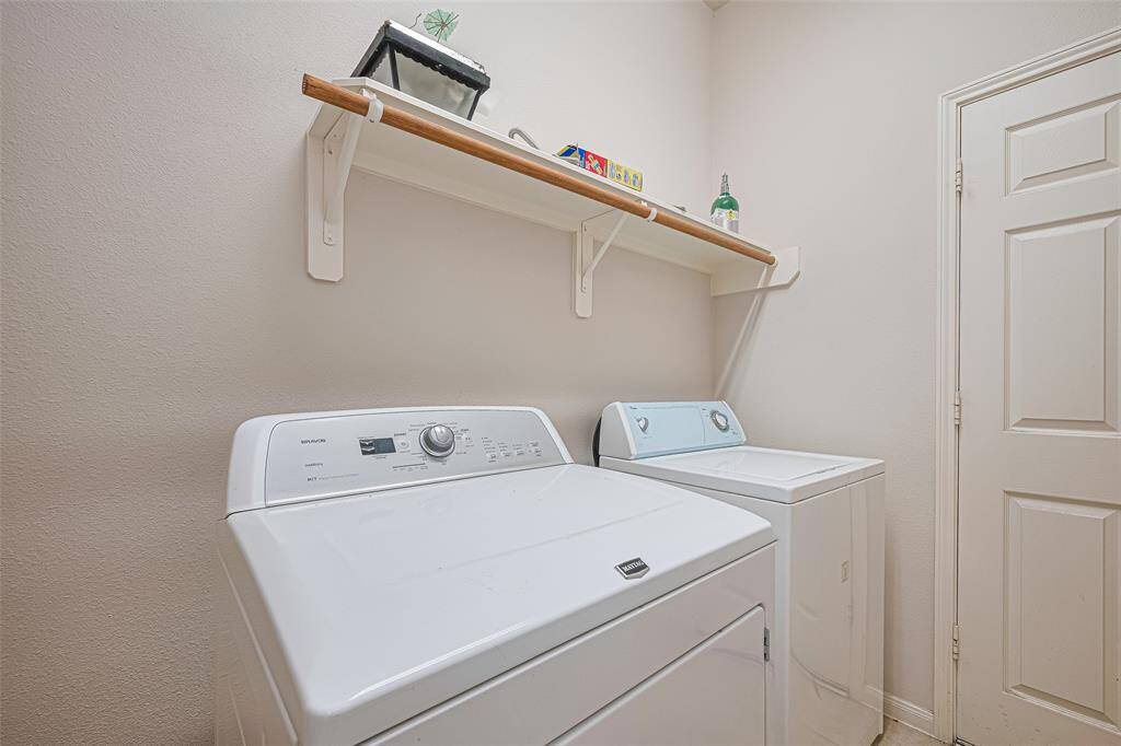 This laundry room is more than utilitarian—it’s well-sized and practical, with built-in shelving and hanging space that makes chores feel just a little more streamlined.