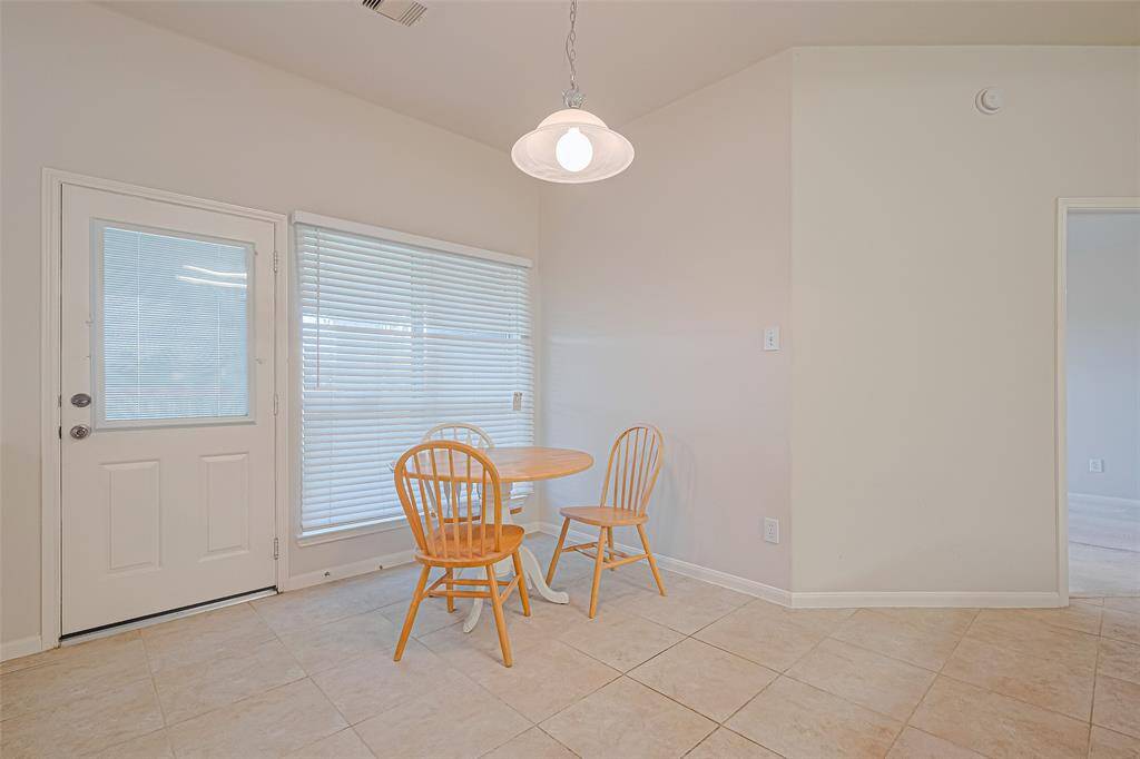 Nestled beside a generous window and glass-paned door to the backyard, the breakfast nook offers a cheerful setting to start your day—with the half wall creating a cozy, defined corner.