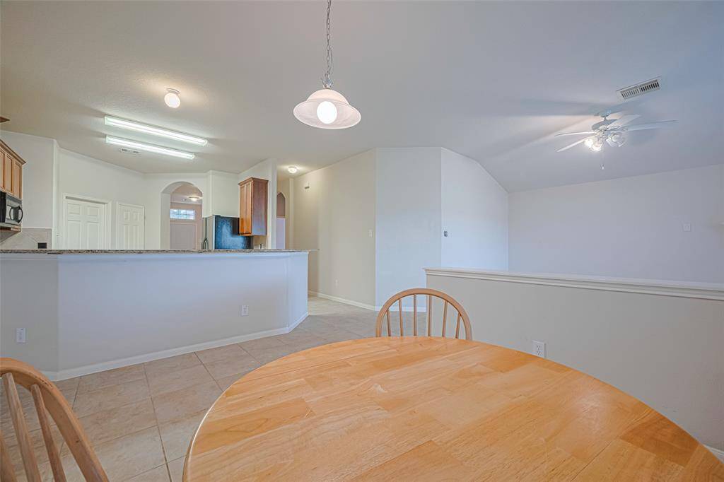 Framed by the kitchen’s raised bar and a partial wall, the breakfast area manages to feel both integrated and intimate—a natural place for morning coffee or casual chats.