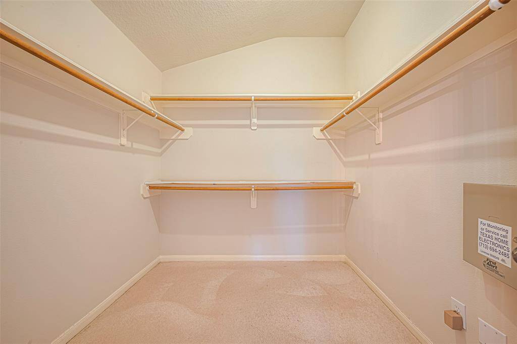 This full-entry, carpeted closet makes storage simple with multiple hanging rods and built-in shelves—generous enough to keep everything in place and in view.