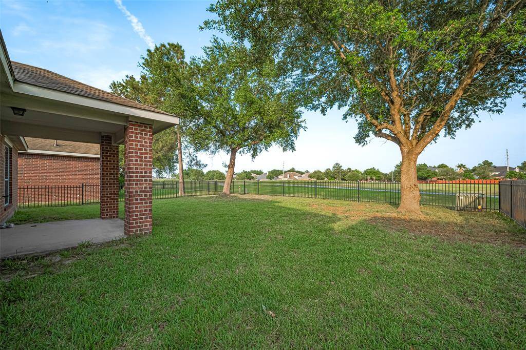 Out back, the covered patio stretches out as a shaded extension of the living space—perfect for quiet afternoons, outdoor meals, or simply enjoying the breeze.