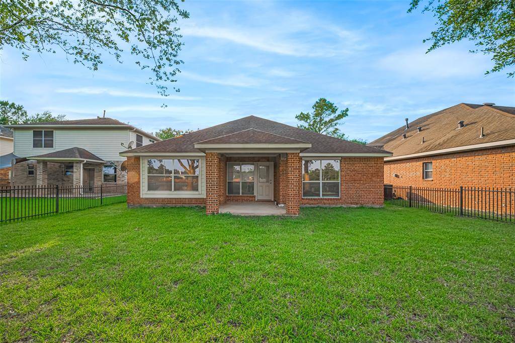 From the backyard, the home's symmetry is on full display, with the central patio providing a focal point framed by soft landscaping.