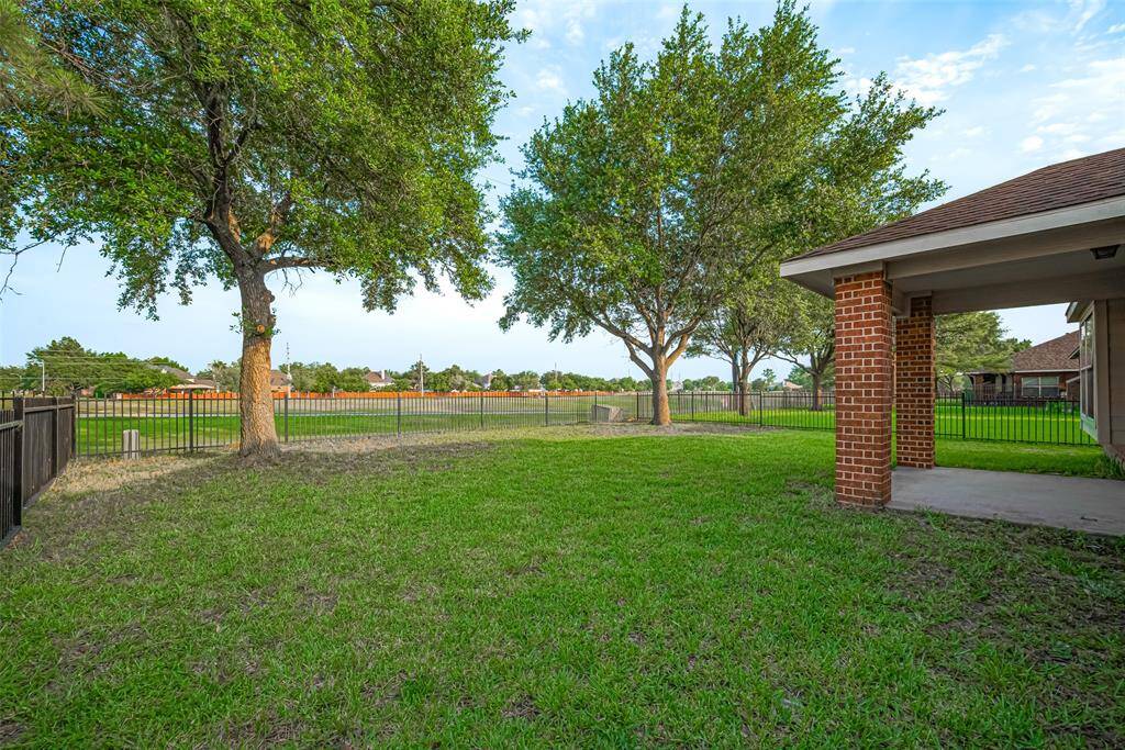 The wrought iron fencing blends security with openness, giving uninterrupted views of the golf course beyond while the spacious lawn invites endless possibilities—from a garden plot to evening games under the sky.