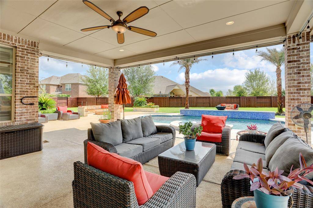 Unwind poolside under a shaded patio surrounded by mature landscaping. This backyard oasis blends comfort and style for outdoor living.