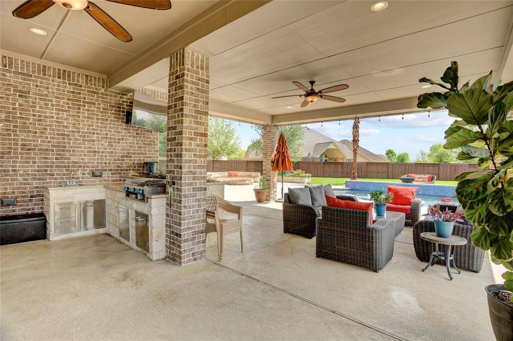 This covered patio offers built-in cooking space, shaded seating, and poolside views—perfect for gatherings and unwinding outdoors.
