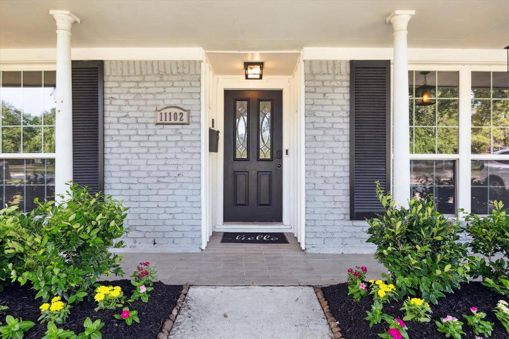 Inviting entry with fresh landscaping.