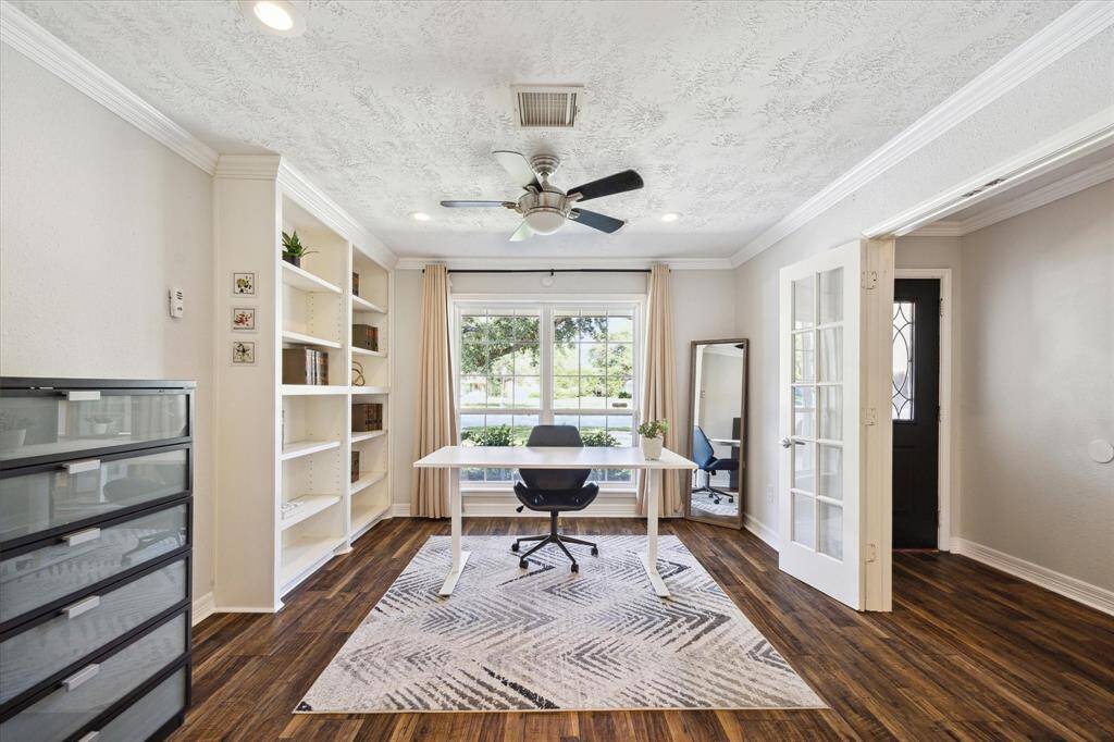 Dedicated home office featuring built-ins and two sets of double French doors.