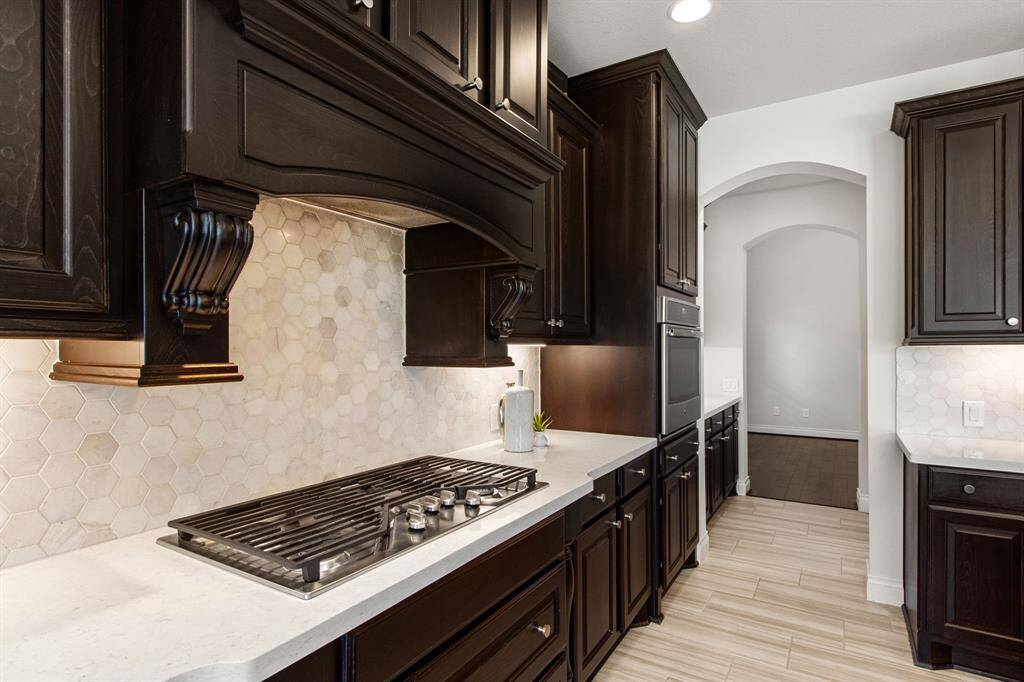 Gorgeous hexagon tile backsplash, gas range, and custom vent hood.