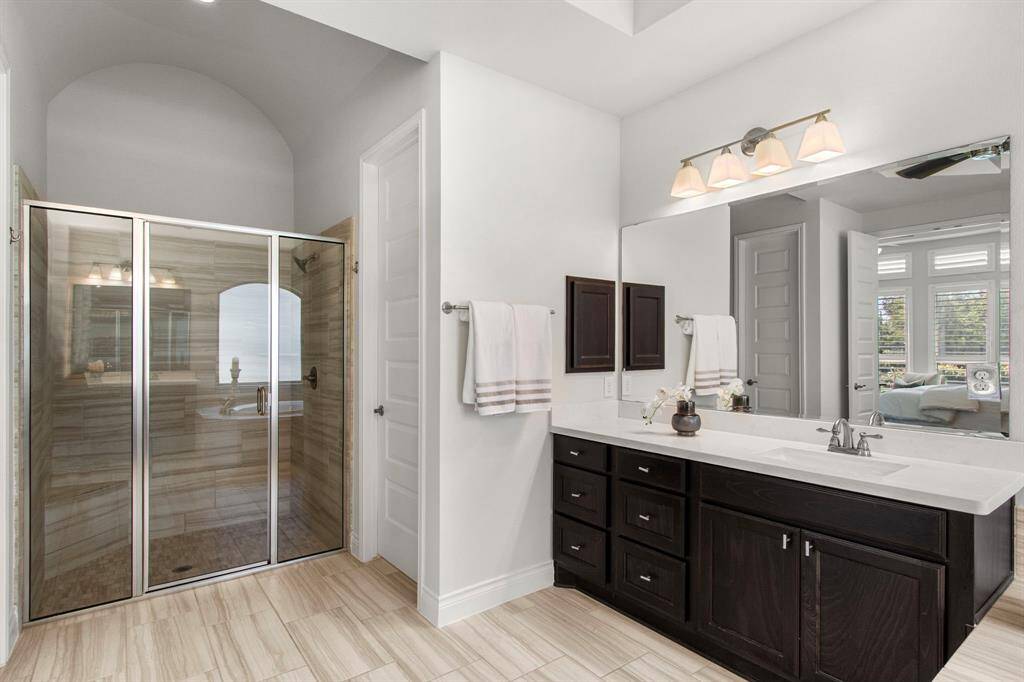 En-suite bathroom with separate vanities and large glass-enclosed shower.