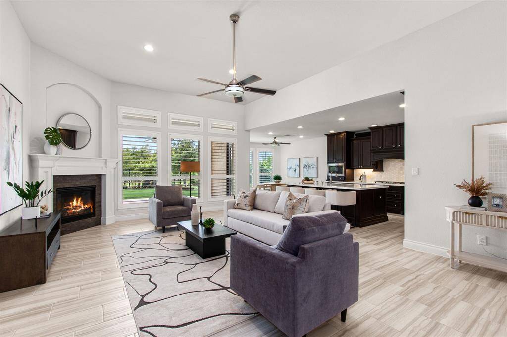 Durable ceramic tile flooring, spacious living with cast stone fireplace, and wall of windows.