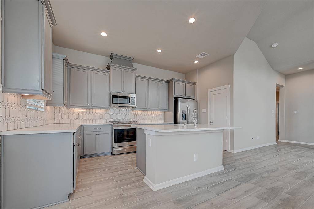 Beautiful kitchen with soft closing drawers and undercabinet lightingDesigned backsplash and wood like tile flooring