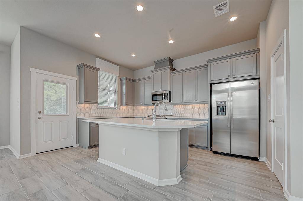 Great kitchen island. White Quartz counter tops The kitchen door leads to a balcony with views of the backyard