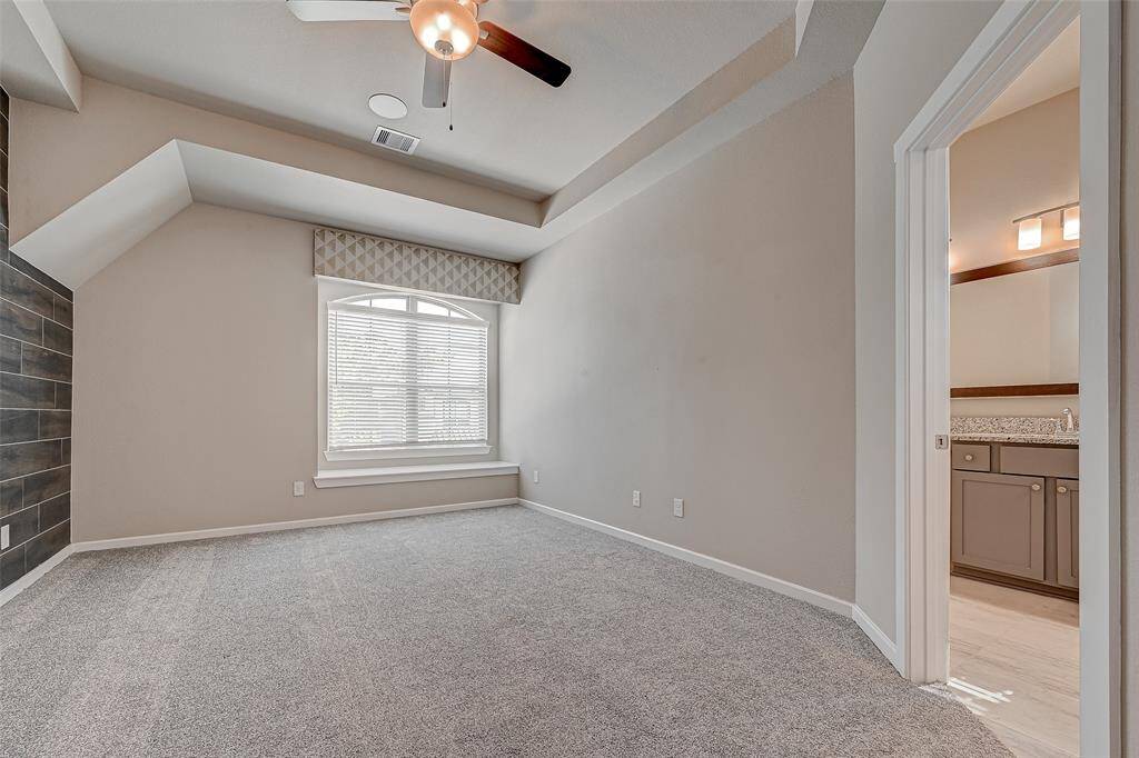 Primary bedroom with sitting area under the window and window decoration