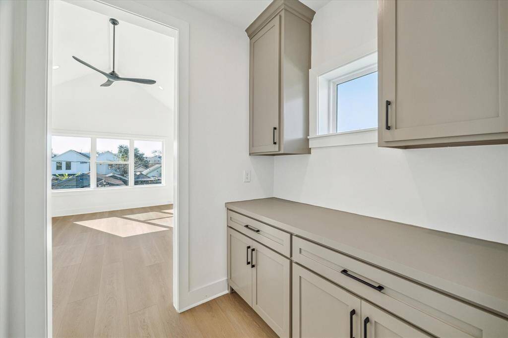 Private primary vestibule/dry bar upon entering the primary suite with storage, electrical outlets and transom window